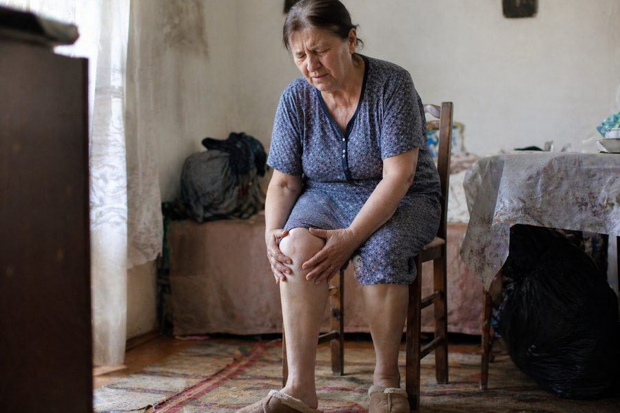 Osoba srednjih godina drži se za bolno koljeno
